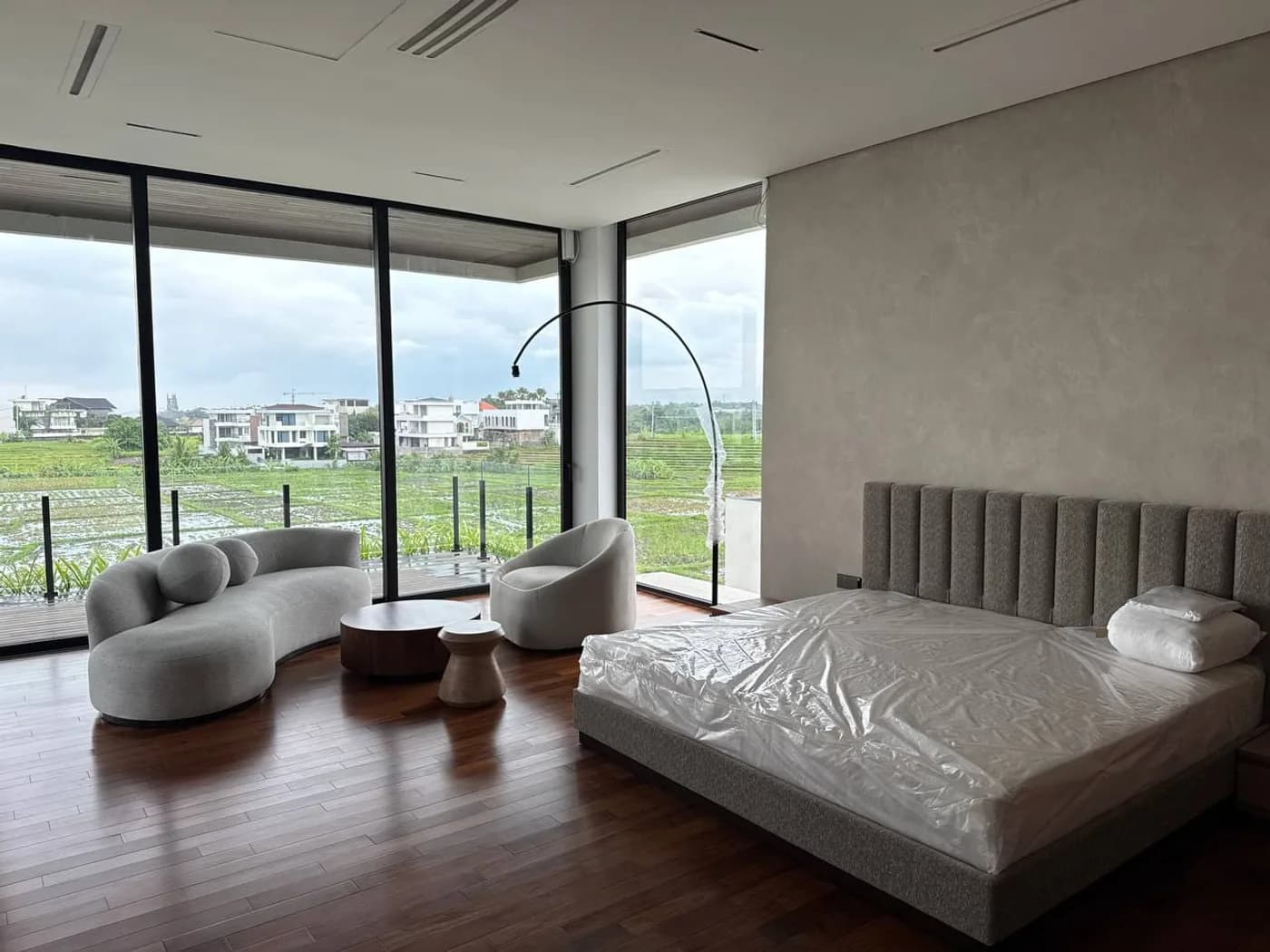 Bedroom with full-height glazing overlooking rice fields