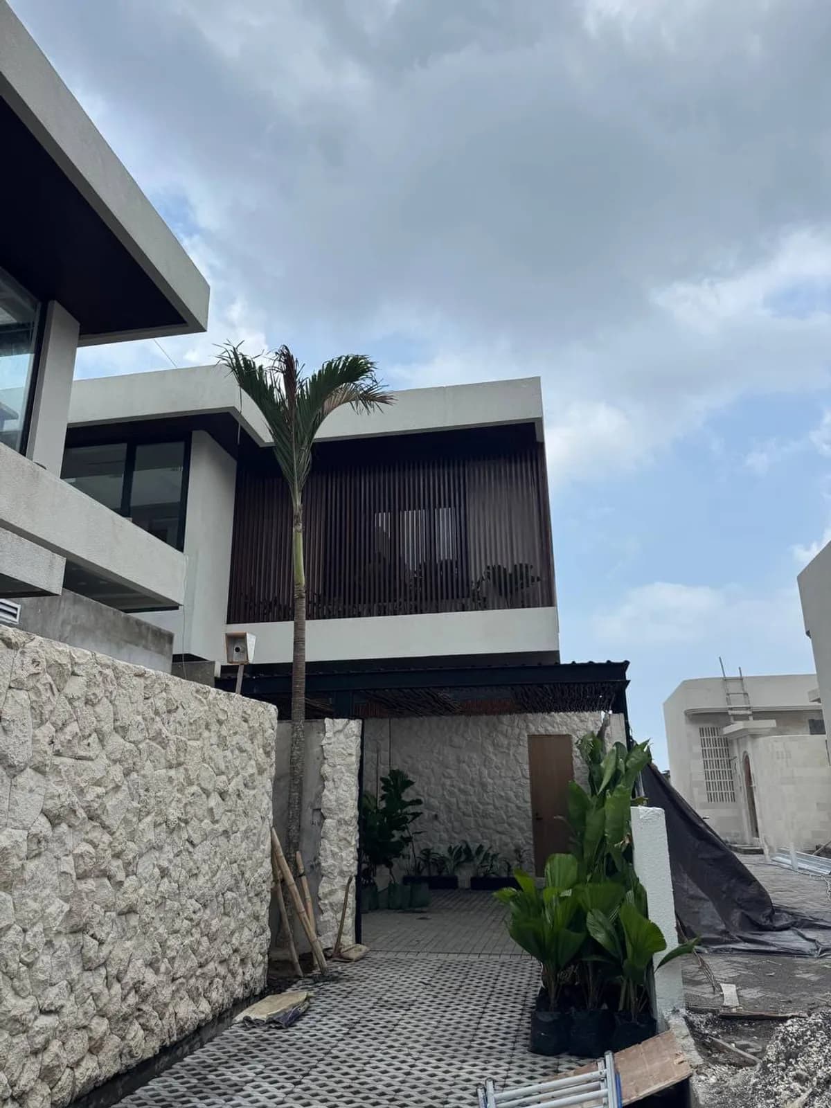 Modern villa facade with timber screens and natural stone walls