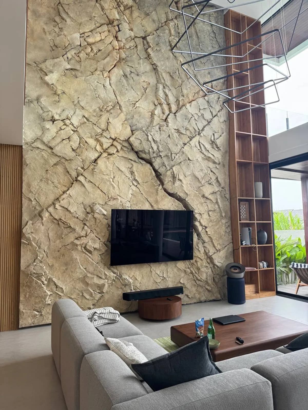 Double-height carved stone feature wall in a living room
